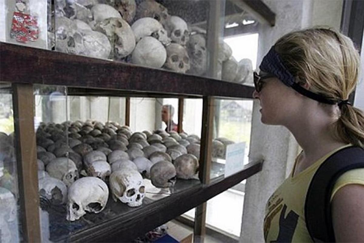 a woman standing in front of a display of skulls