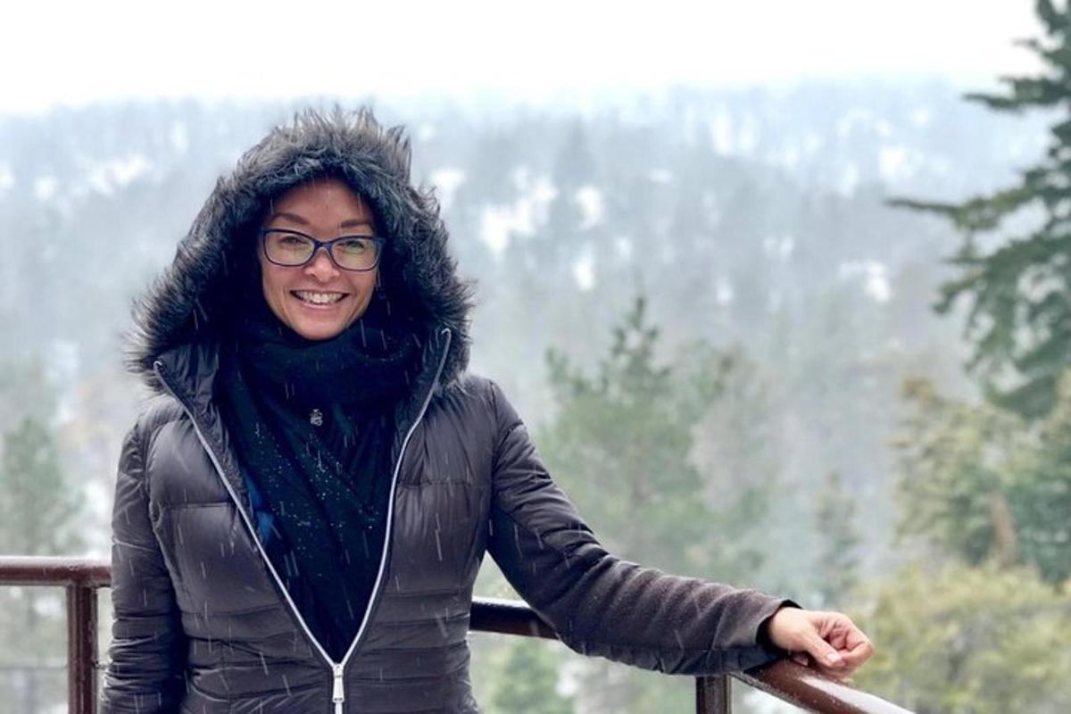 a woman is standing on a rail in the mountains