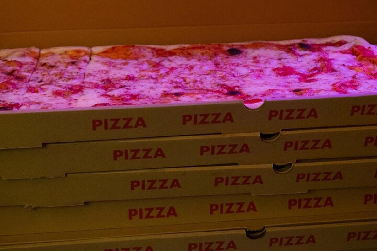 Una pila de cajas de pizza con una pizza