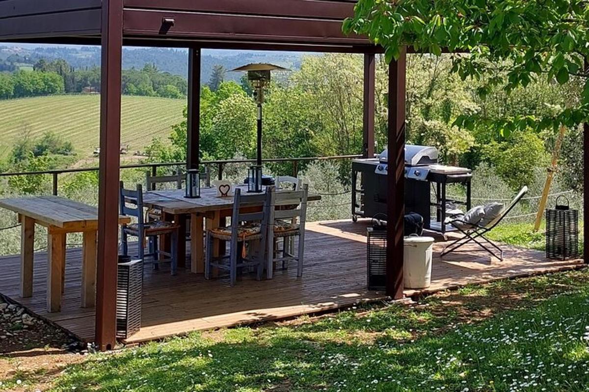 una terrassa de fusta amb una taula i una barbacoa