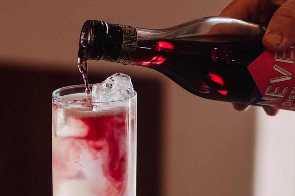 seseorang menuang sebotol wain merah ke dalam gelas