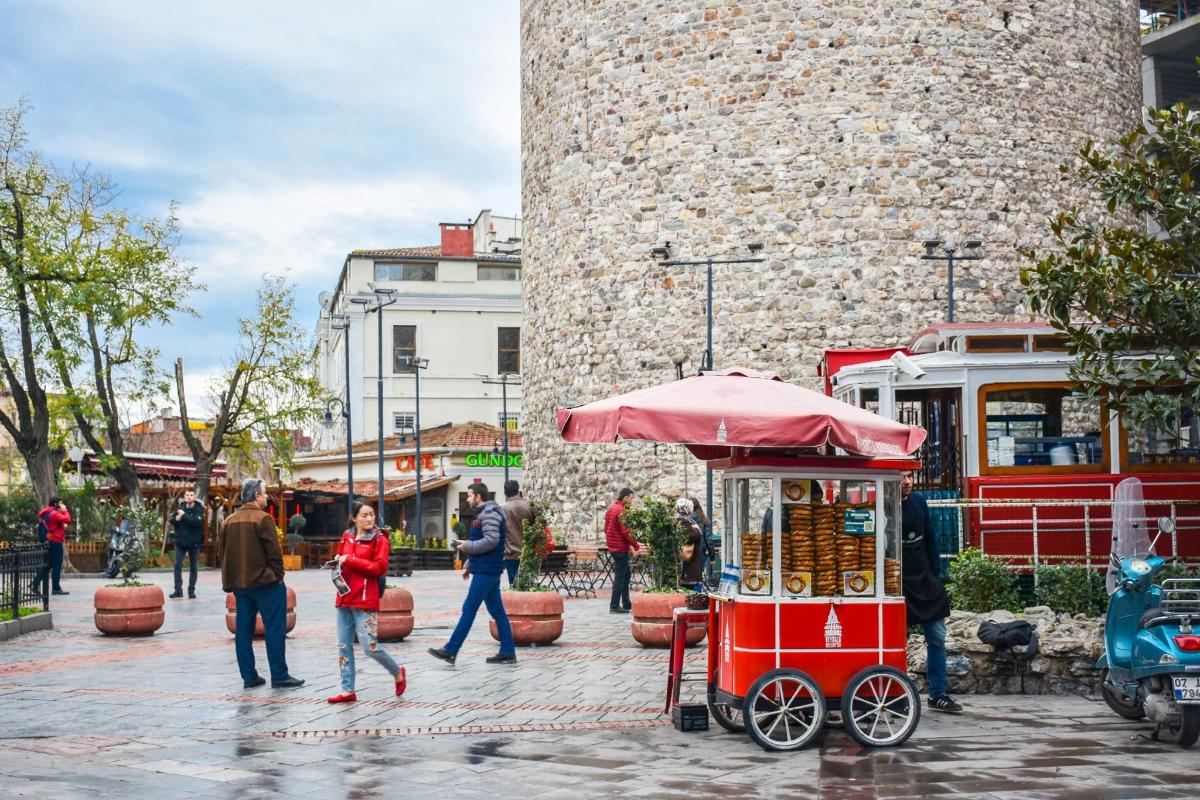 a red food cart in front of a castle