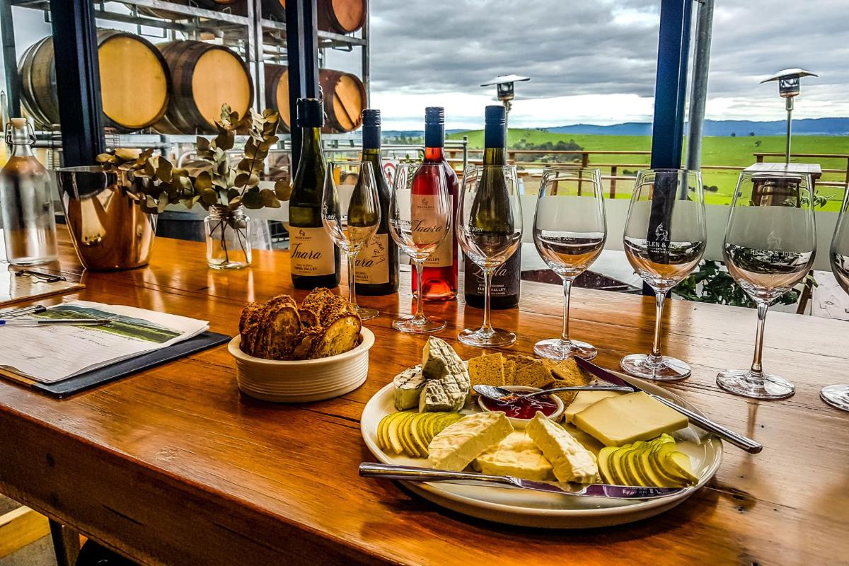 a table with a plate of cheese and wine glasses