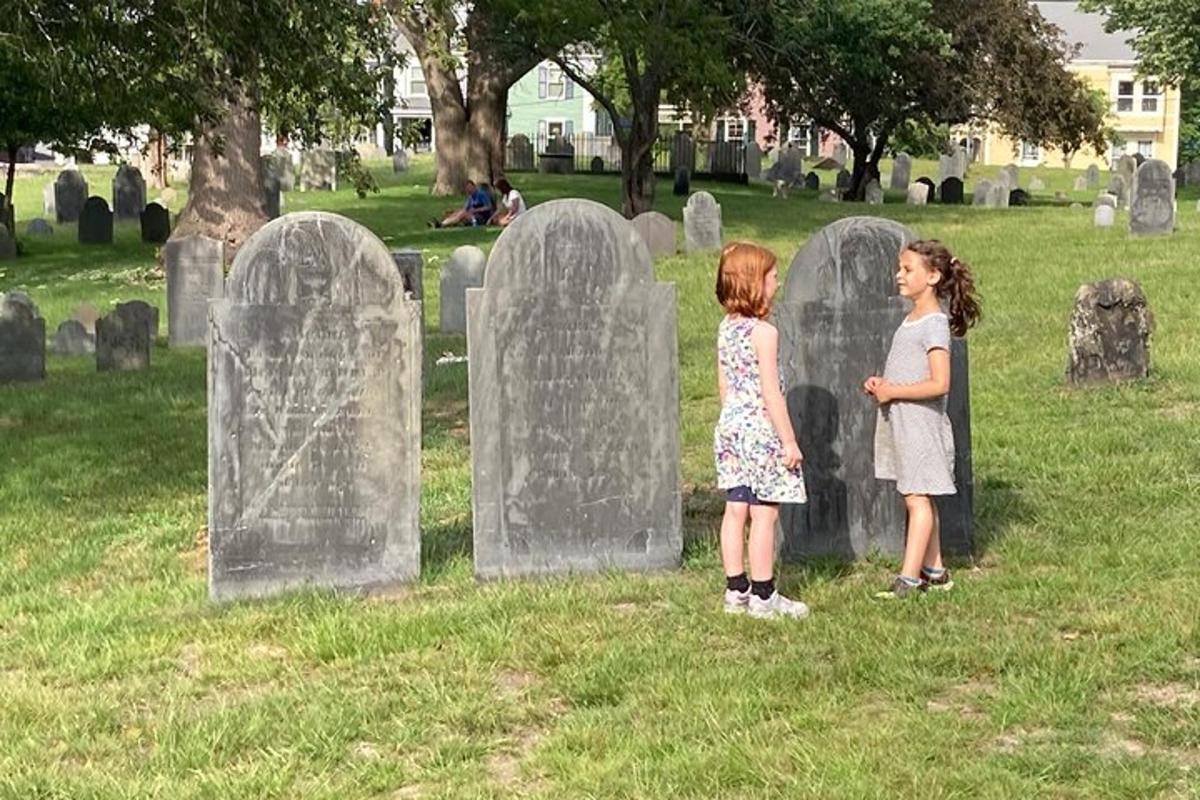 zwei junge Mädchen stehen vor einem Friedhof