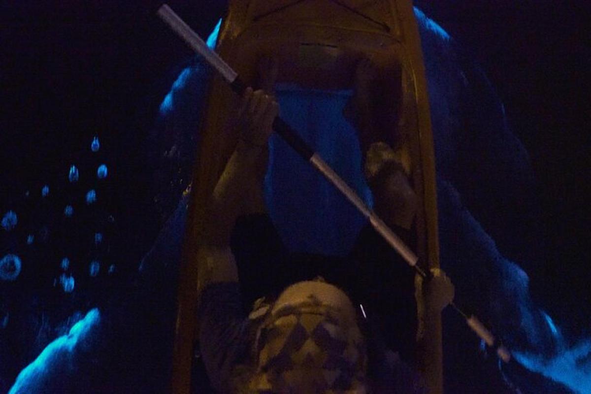 a person in a boat in the water at night