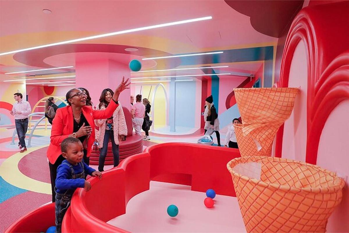 a woman and a child playing in a room with balls