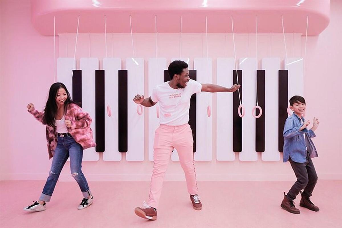 a man and two children standing in front of a piano