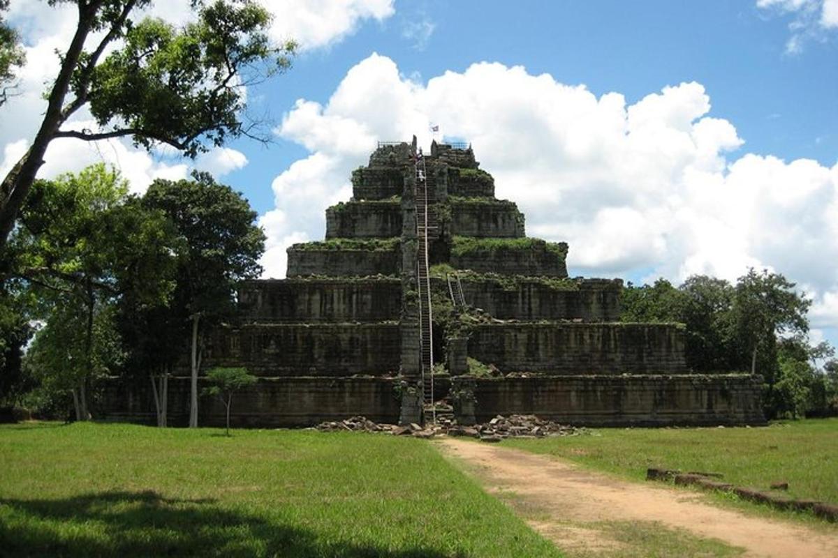 um grande edifício em um campo próximo a uma estrada de terra