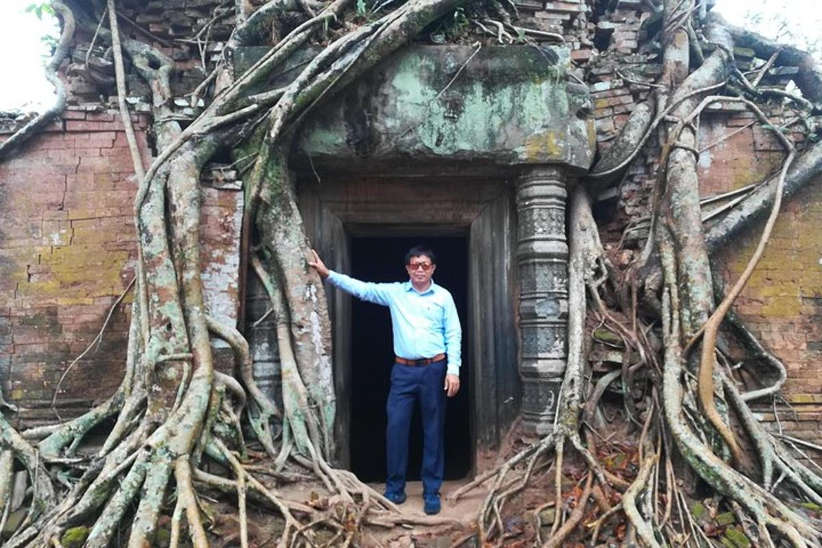 seorang lelaki berdiri di ambang pintu dengan akar pokok