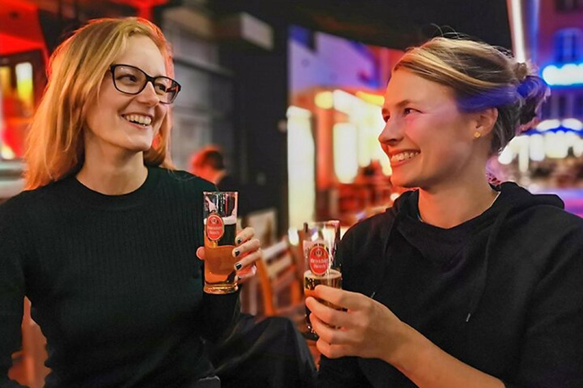Kaks naist naeratavad ja hoiavad õlleklaase