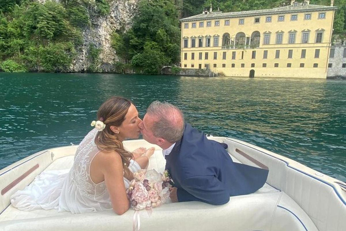 一对新郎新娘带着一个婴儿在船上接吻
