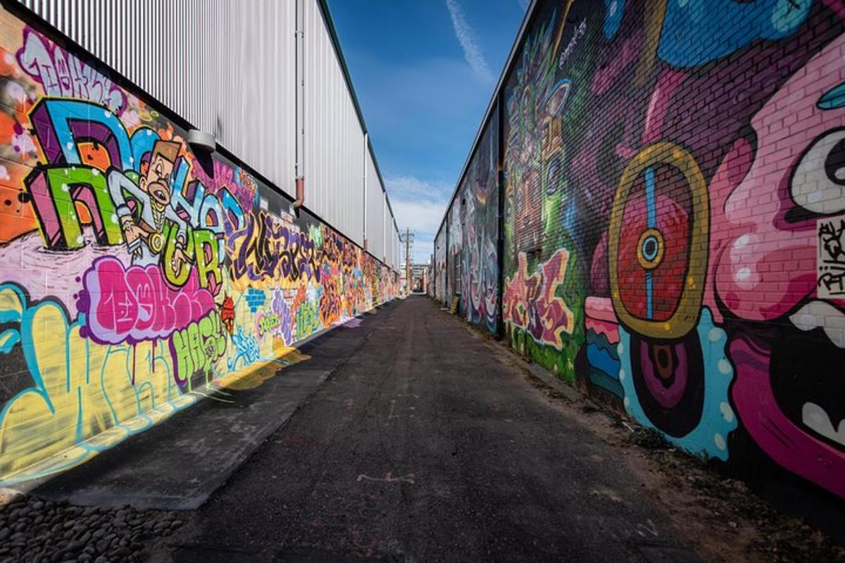 un muro coperto di graffiti accanto a una strada