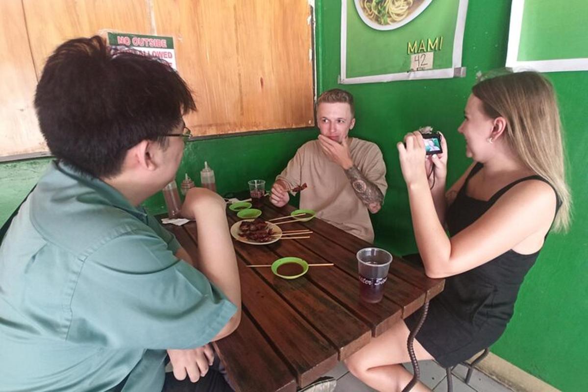 a man taking a picture of two people sitting at a table