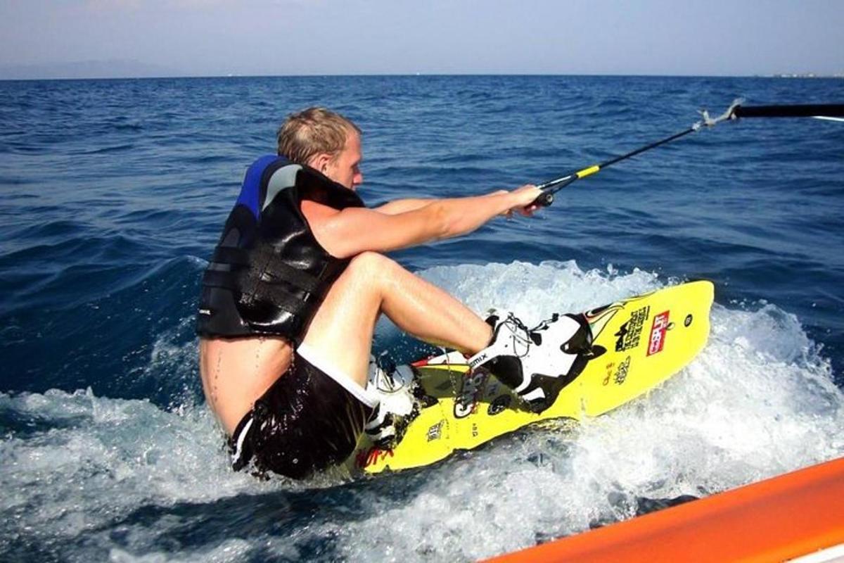 muž sedící na paddleboardu ve vodě