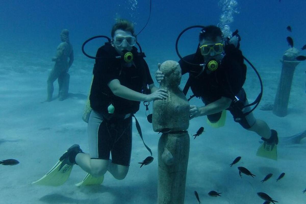 a group of people in the water with a statue