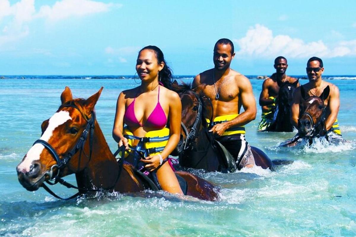 skupina ljudi, ki jahajo konje v oceanu