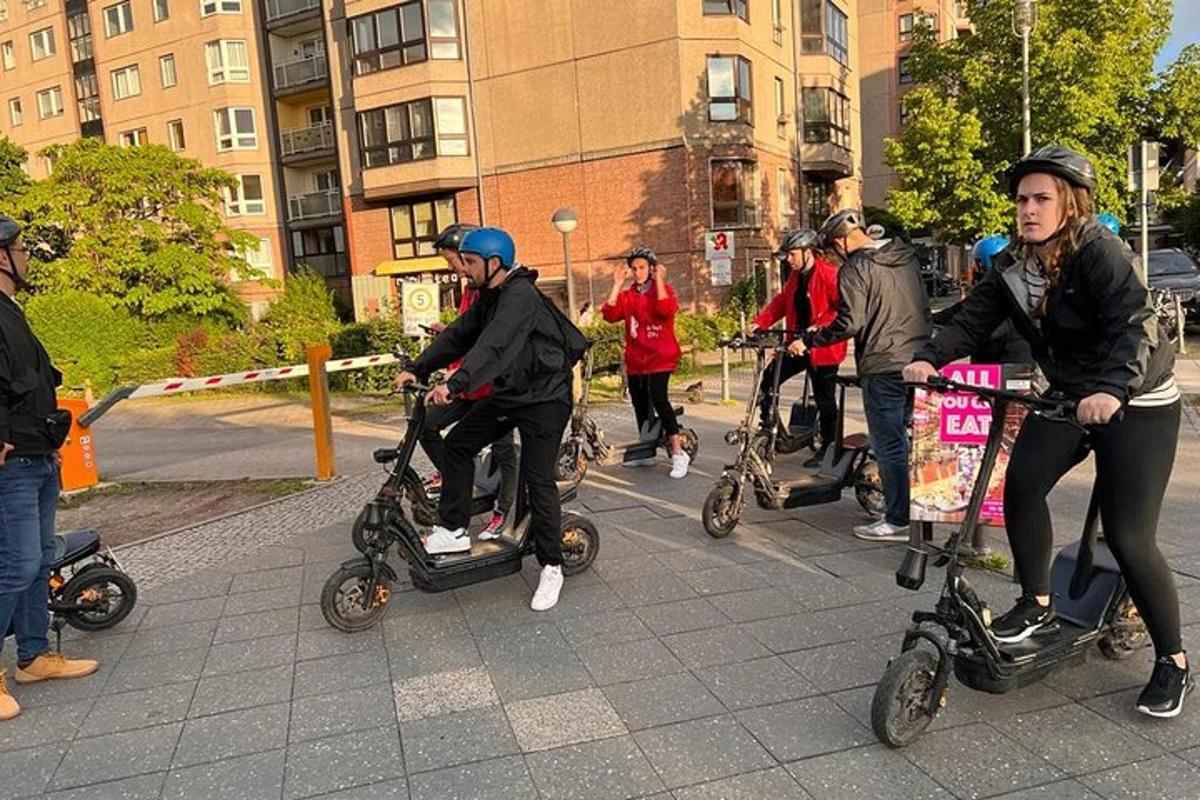 um grupo de pessoas andando de scooter pela rua