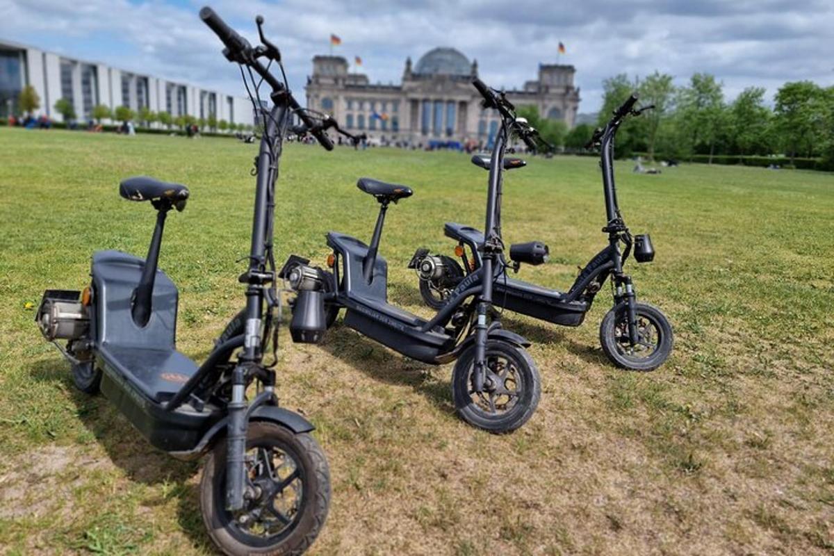 tre scooter parcheggiati sull'erba in un parco