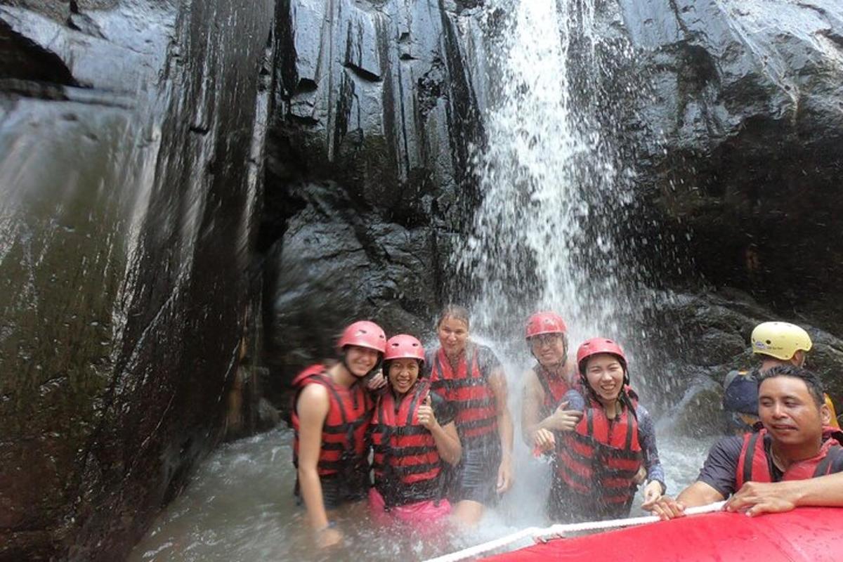 eine Gruppe von Menschen auf einem Floß in einem Wasserfall