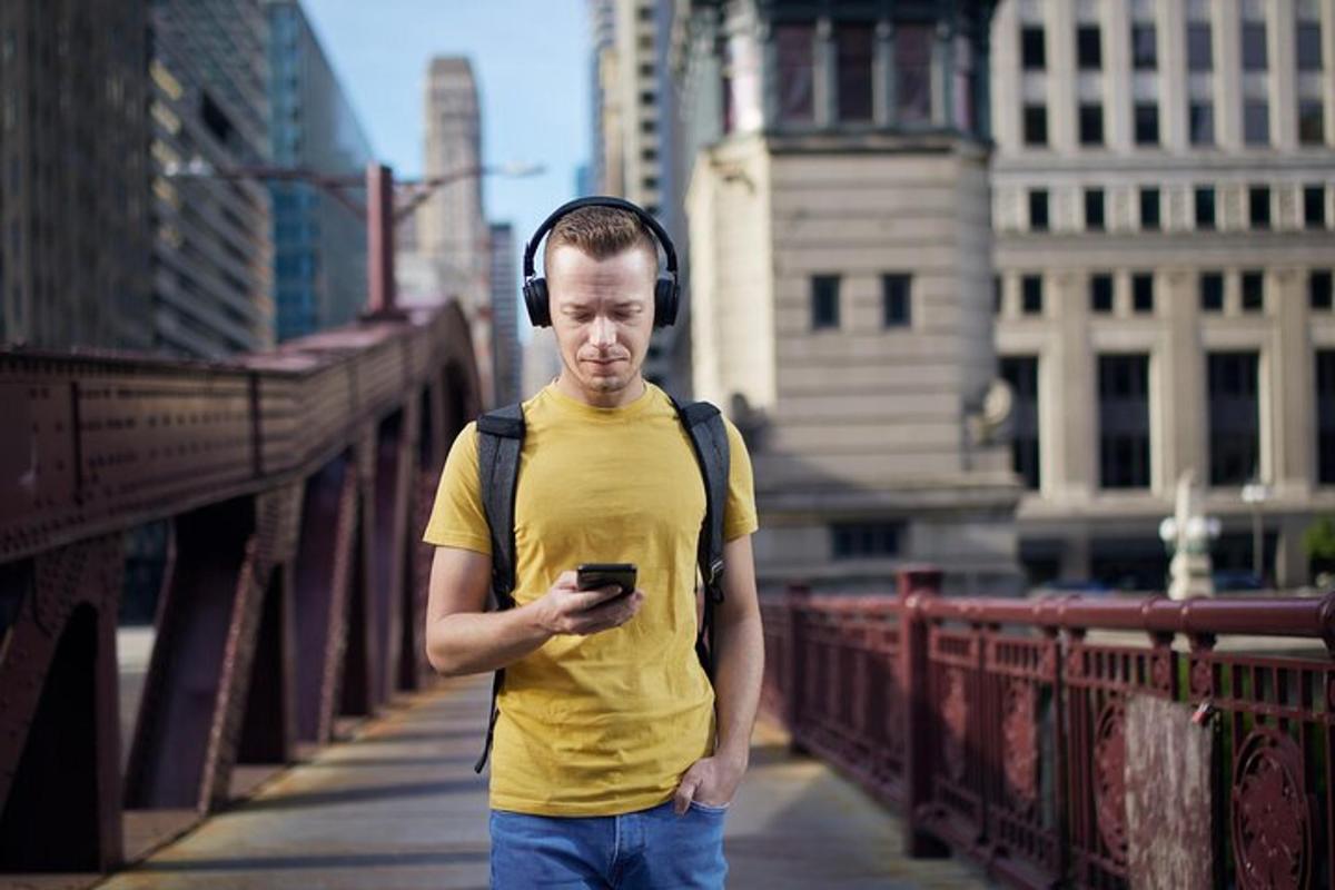 a man wearing headphones is looking at his cell phone