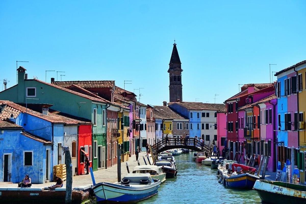 a group of colorful buildings next to a canal with boats
