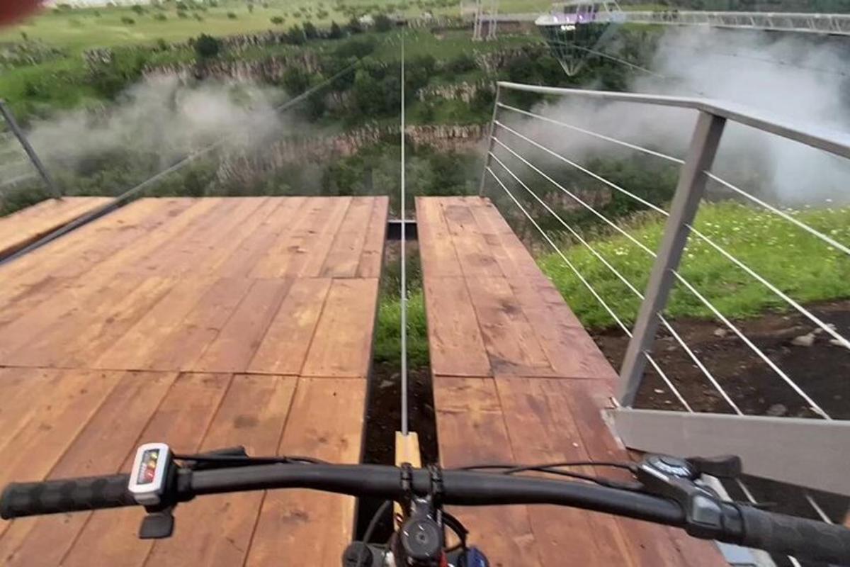una persona in bicicletta su un ponte di legno