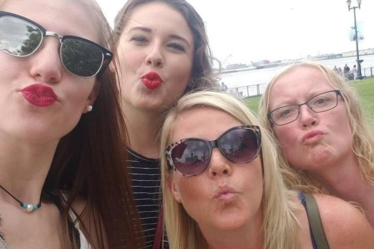 neljast naisest koosnev grupp, kes kannavad päikeseprille ja punast huulepulka