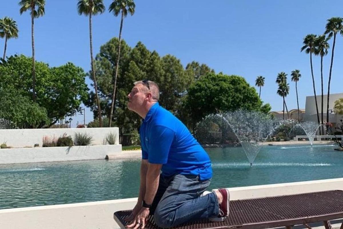 a man sitting on a bench in front of a fountain
