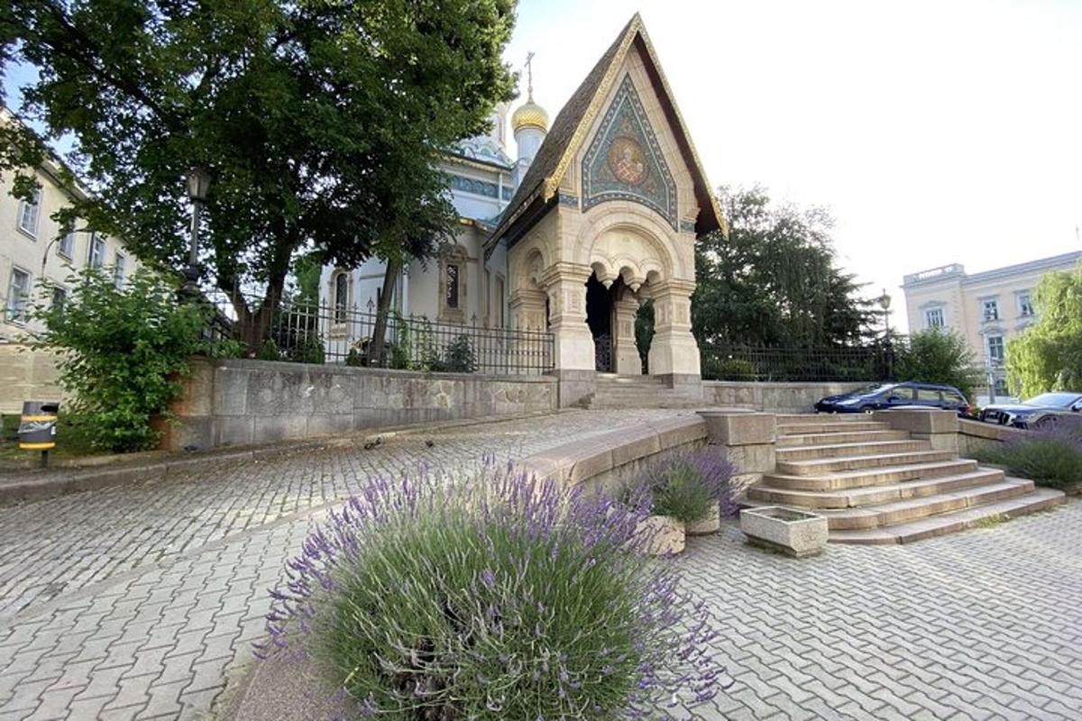 a building with stairs and a church with purple flowers