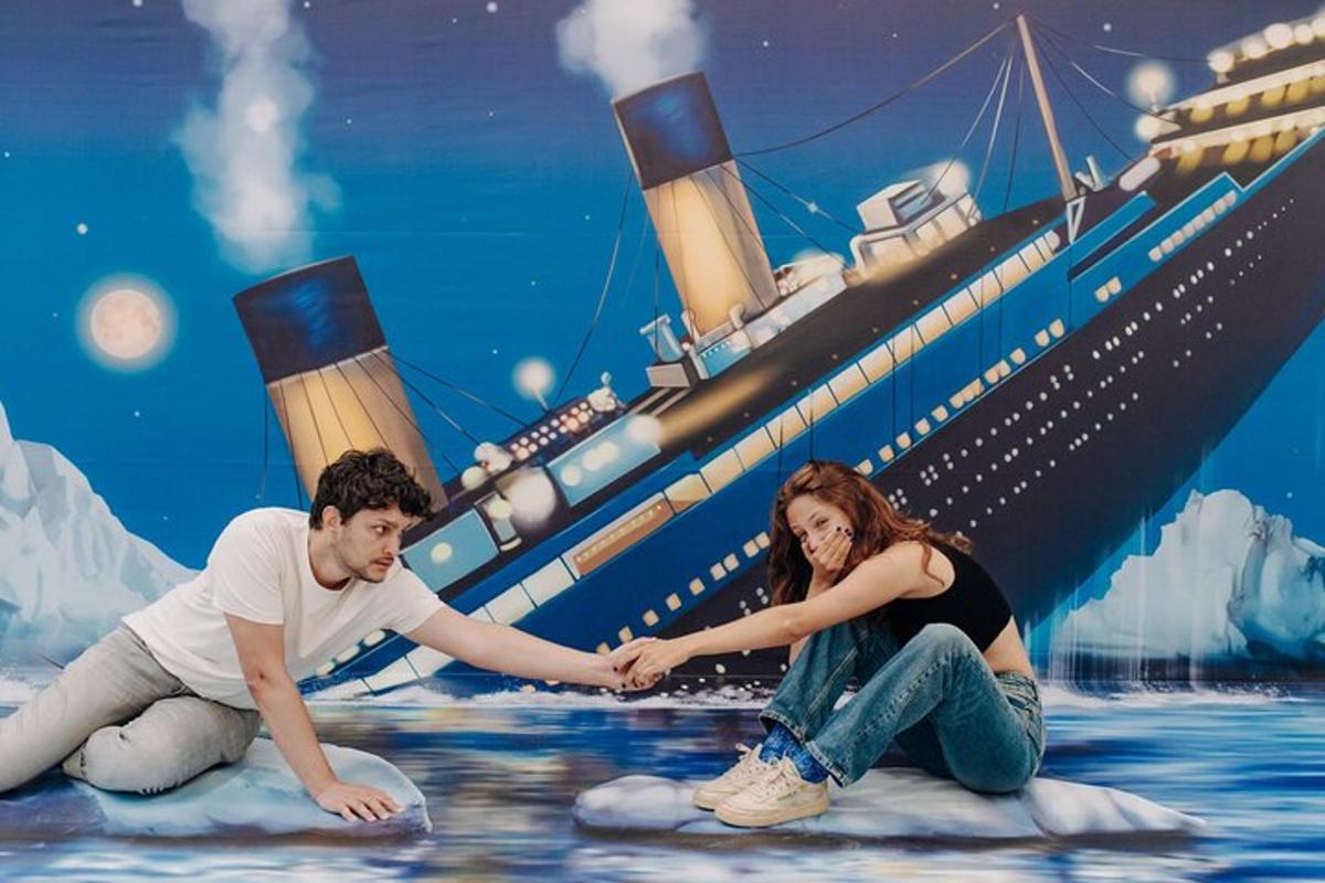 a man and a woman sitting on a iceberg in front of a ship