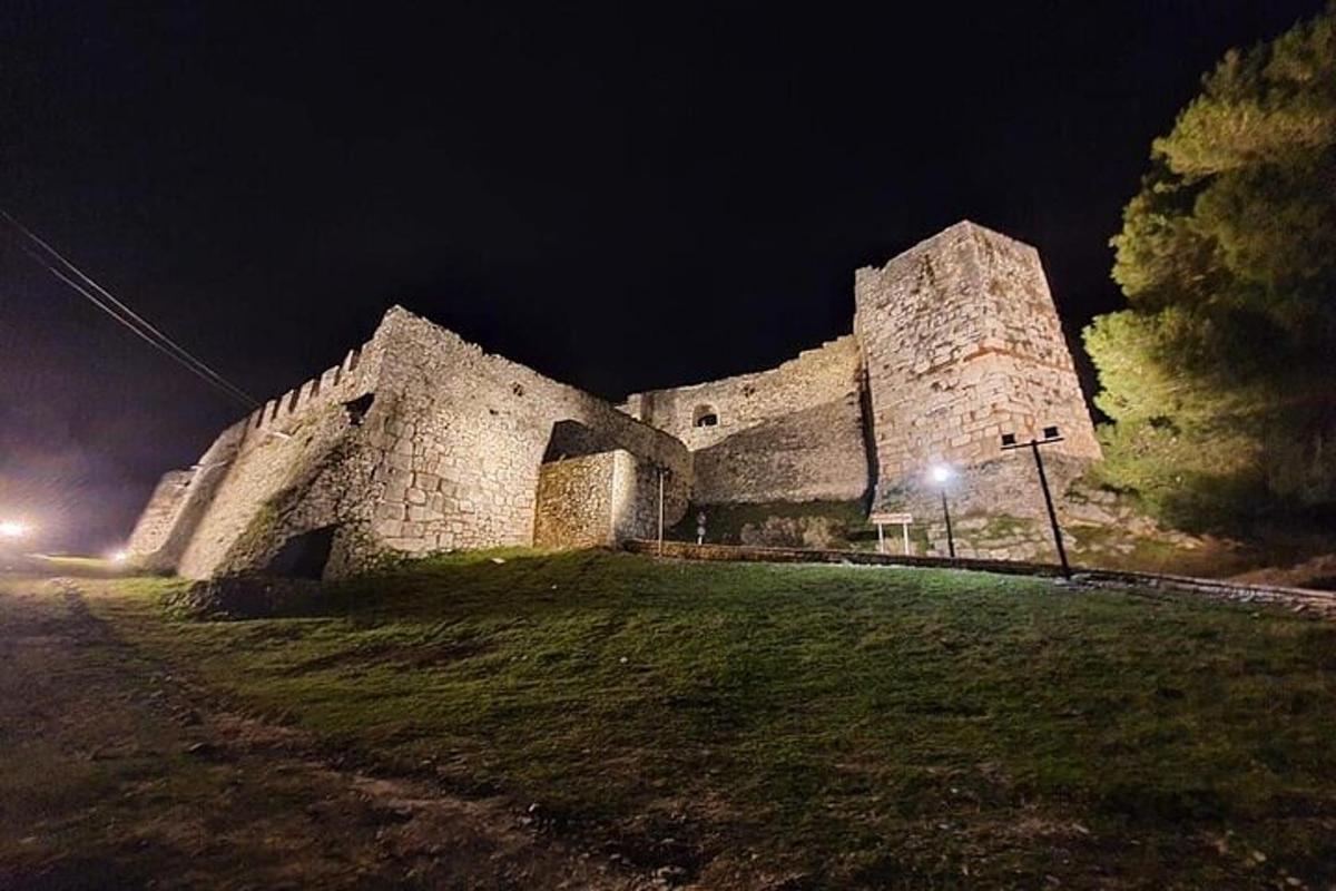 un grande edificio in pietra di notte con un lampione