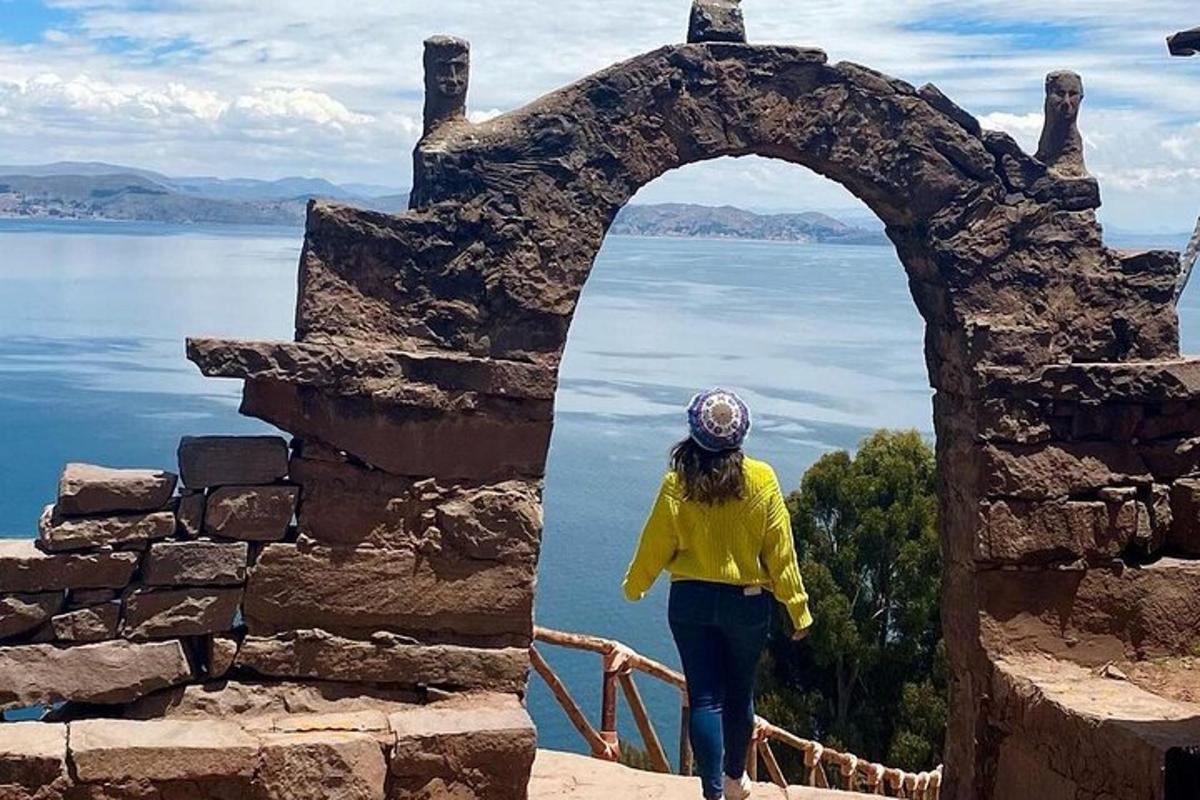 a woman walking through an archway over a body of water