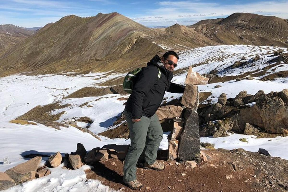 un home dret al cim d'una muntanya coberta de neu