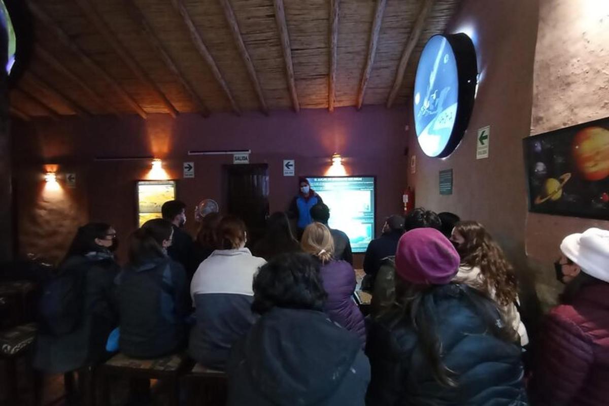 grupp inimesi toas, kus ekraanil on mees