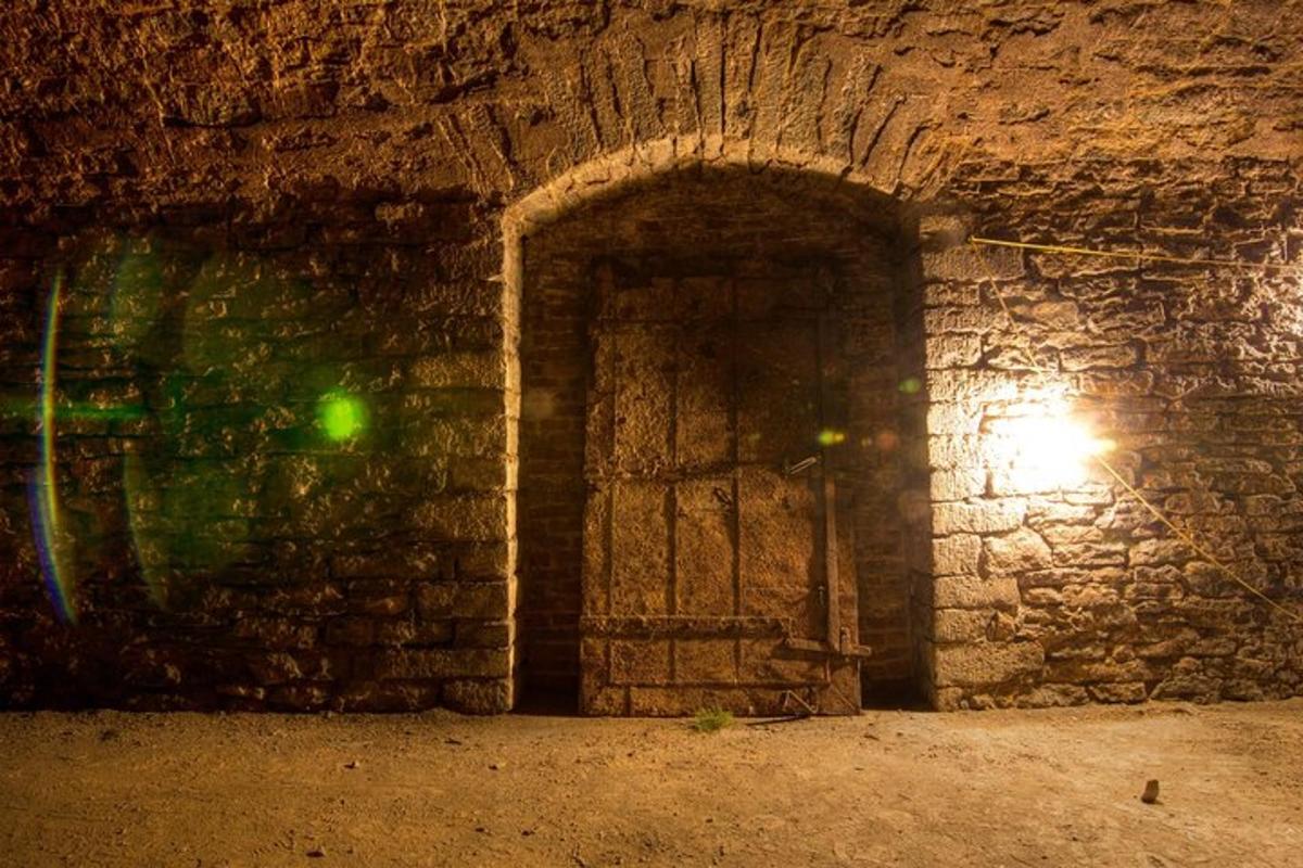 a door in a stone wall with a light on it