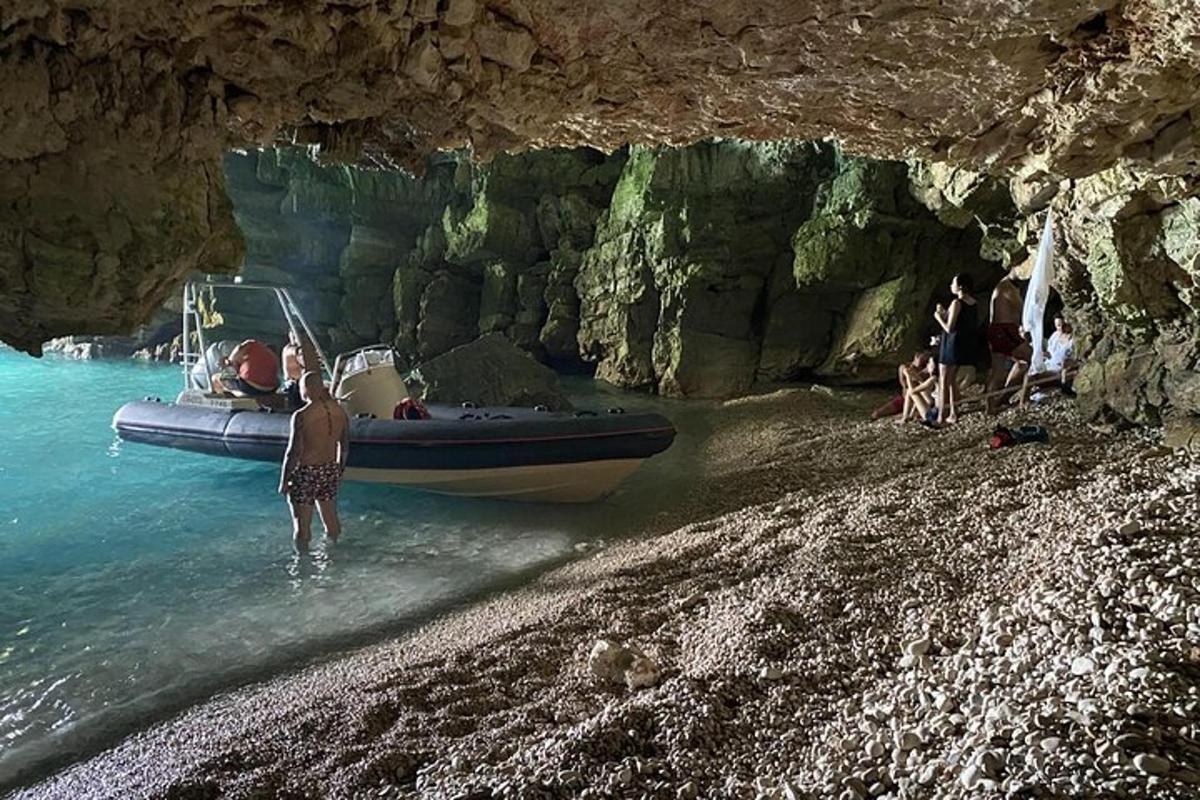 oseba, ki stoji v vodi poleg čolna na plaži