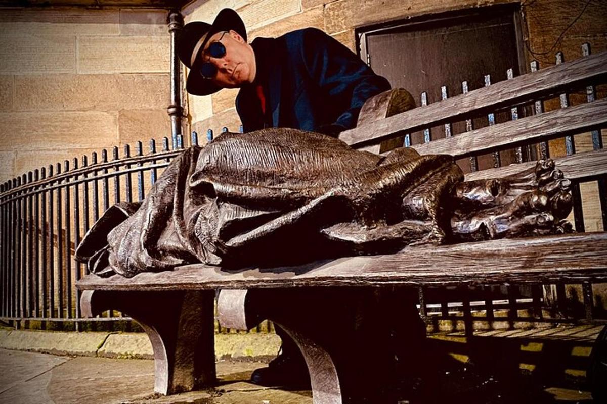 a man standing next to a statue of a fish on a bench