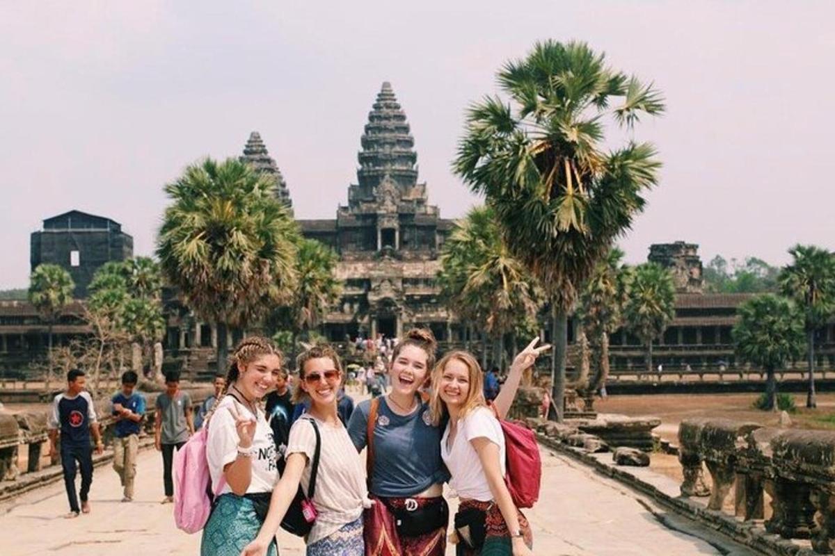three women pose for a picture in front of a temple