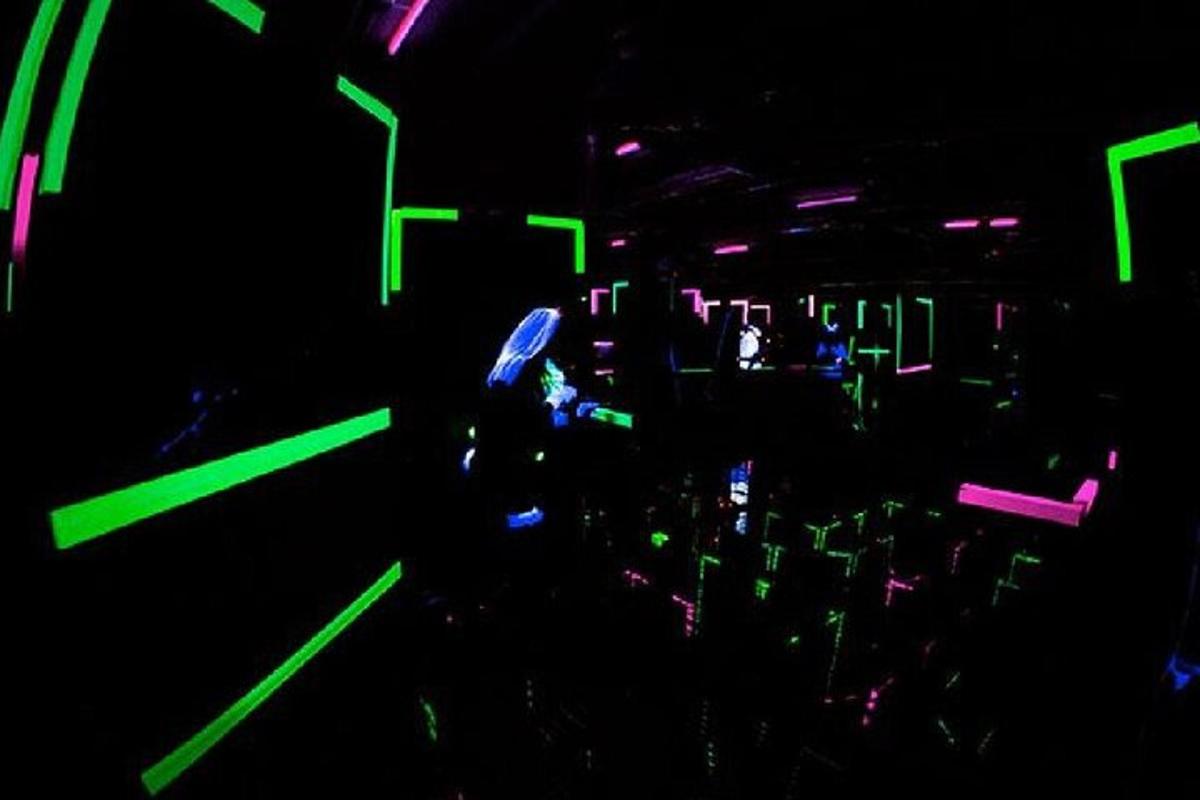 um quarto escuro com luzes verdes e roxas