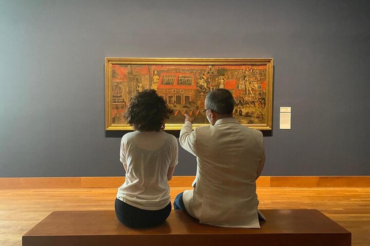 a man and woman sitting on a bench looking at a painting