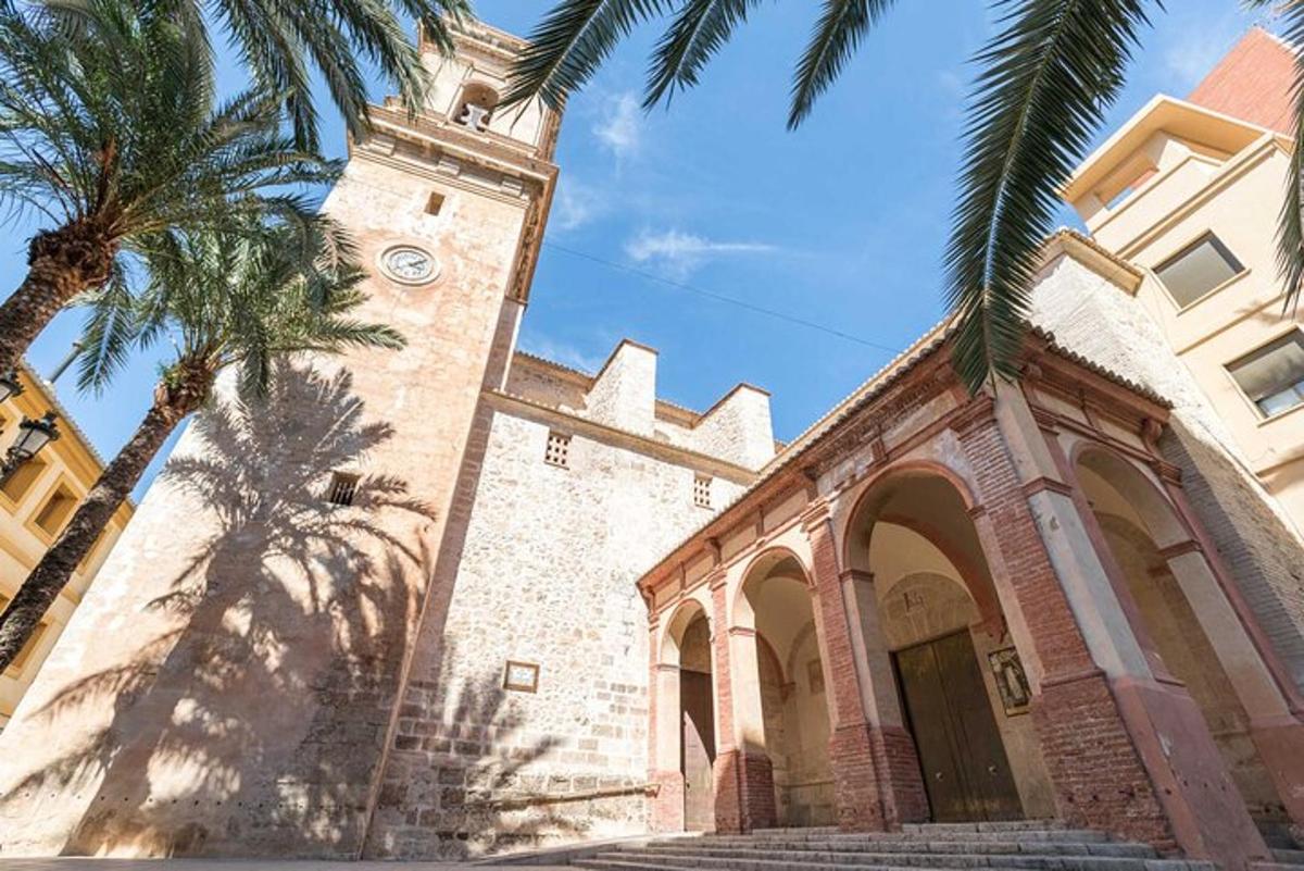 una iglesia con una torre de reloj y palmeras