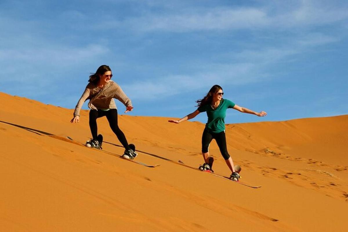 two women are rollerblading down a sand hill