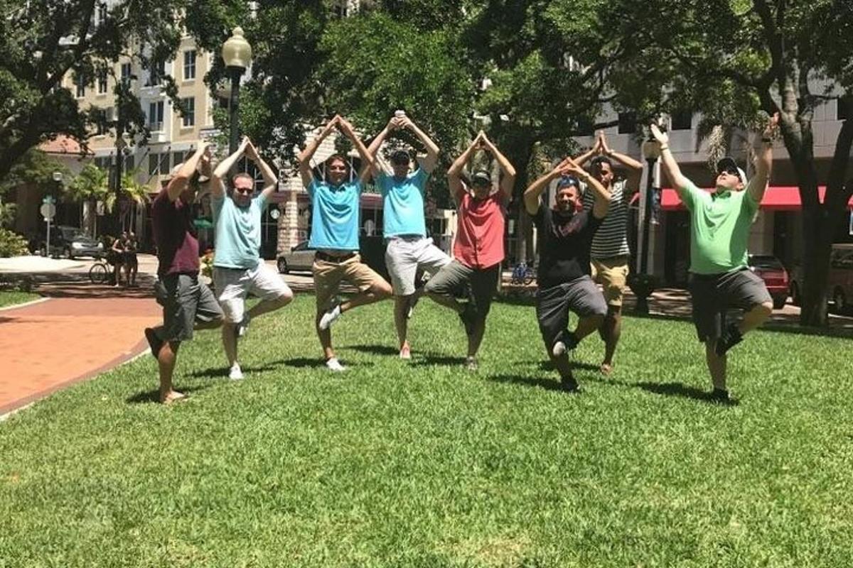 sekumpulan orang melakukan pose yoga di rumput