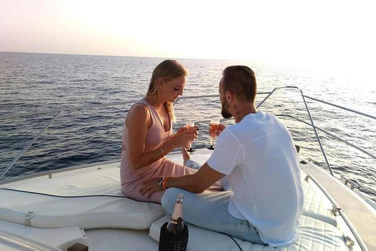 ein Mann und eine Frau sitzen mit Getränken auf einem Boot