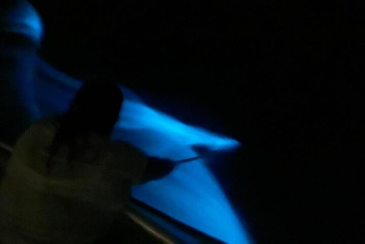a person standing in the dark with a blue light