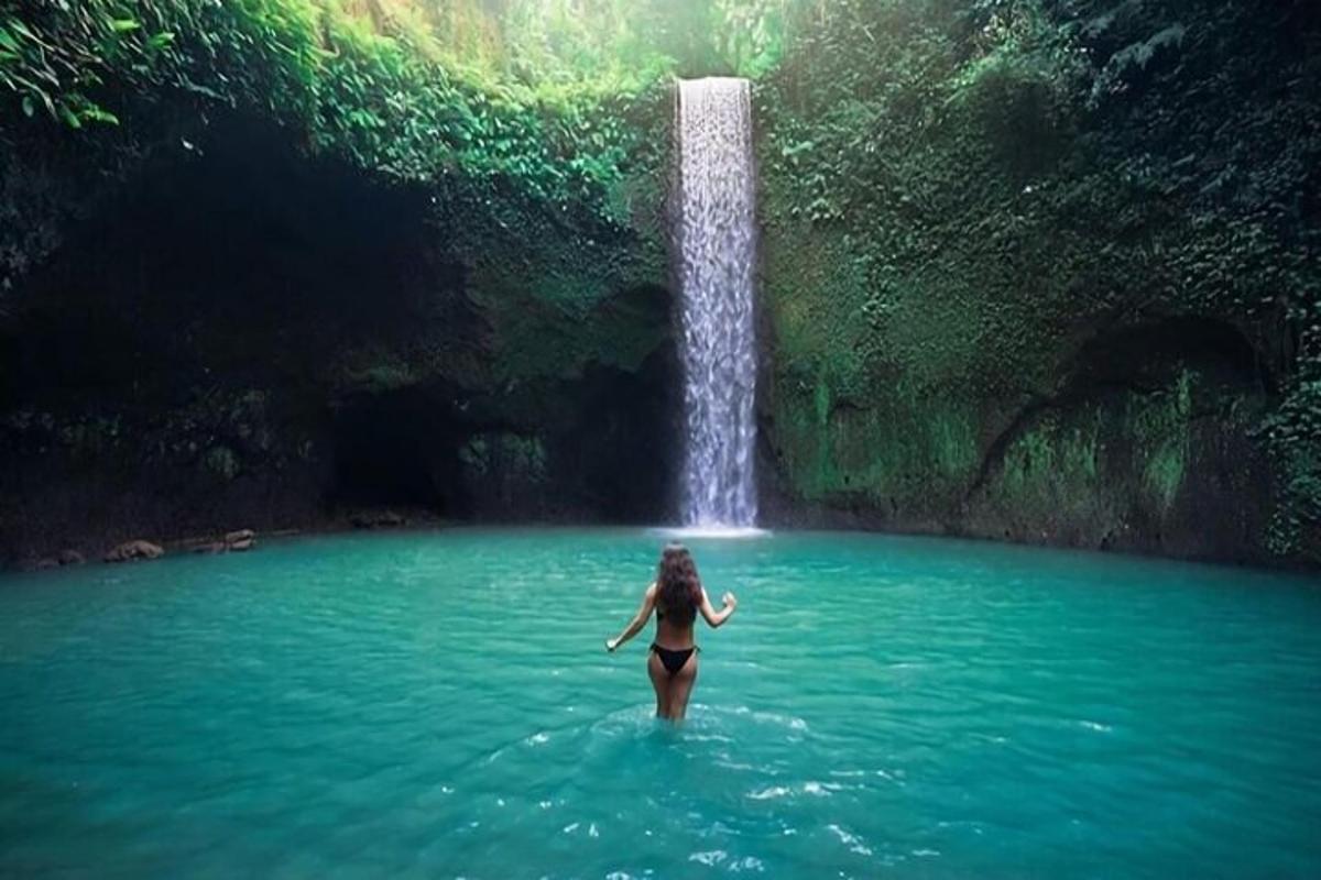 seorang wanita di dalam air di hadapan air terjun