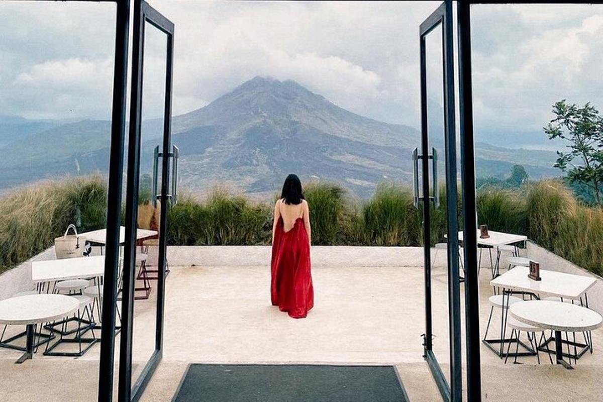a woman in a red dress looking at a mountain