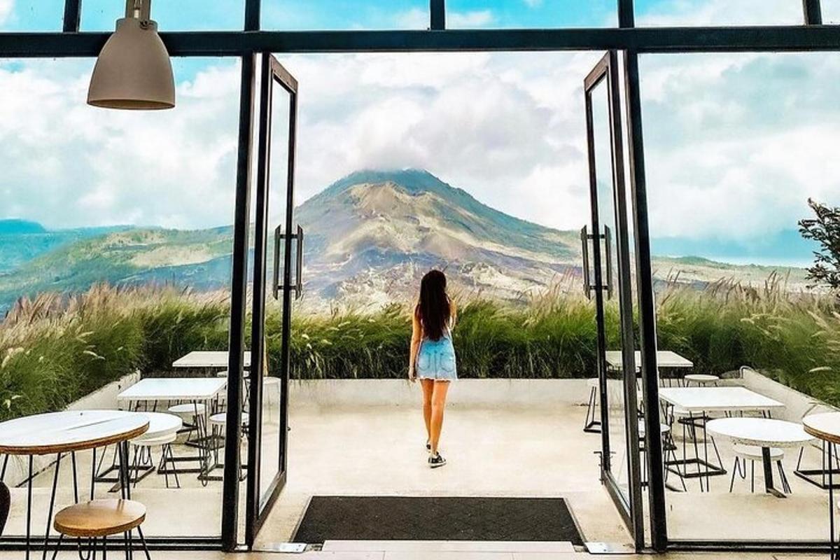 a woman walking through a glass door looking at a mountain
