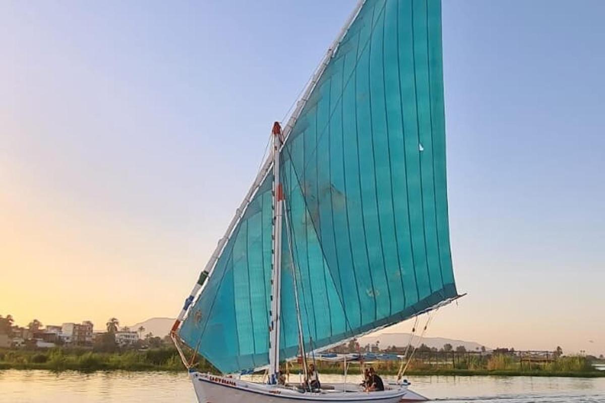a boat with a green sail on the water