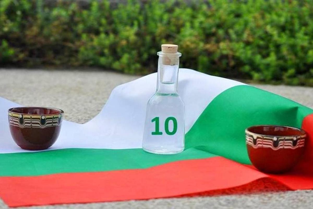 sebotol di atas bendera dengan dua cawan